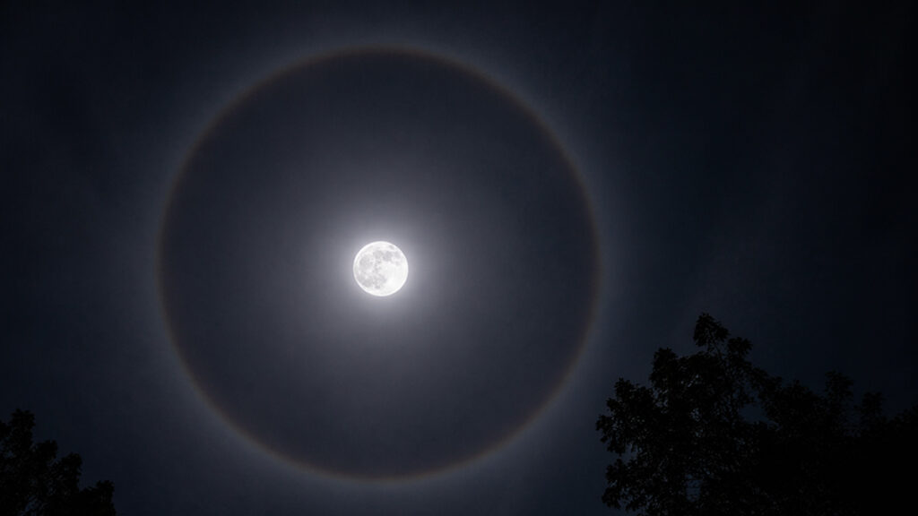 Lunar halo atau lingkaran cahaya di sekitar bulan pada langit malam yang gelap