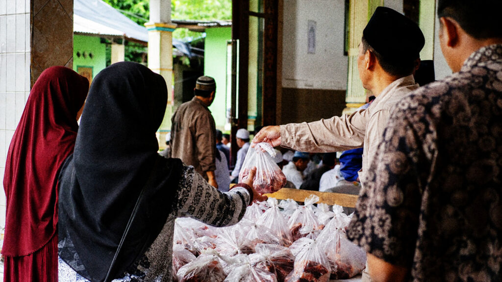 Panitia qurban membagikan daging qurban kepada warga di lingkungan masjid saat Idul Adha.