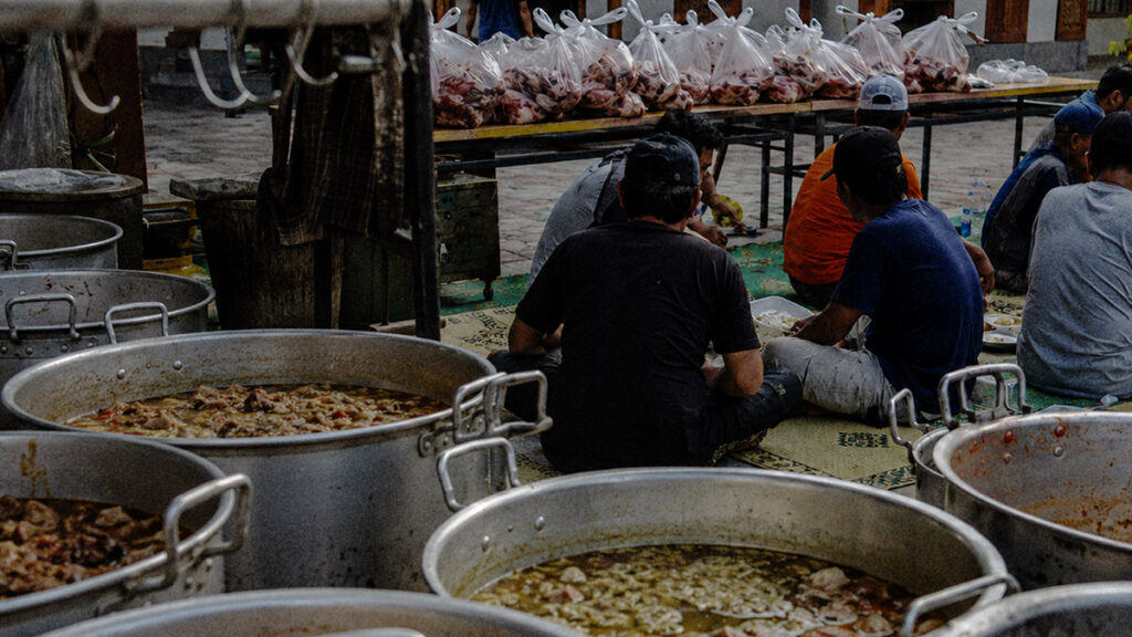Panitia qurban makan bersama setelah proses pembagian daging qurban di halaman masjid