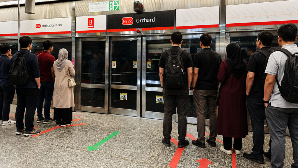 Penumpang mengantre dengan tertib di peron MRT di Singapura mengikuti garis antrean yang ditandai di lantai.
