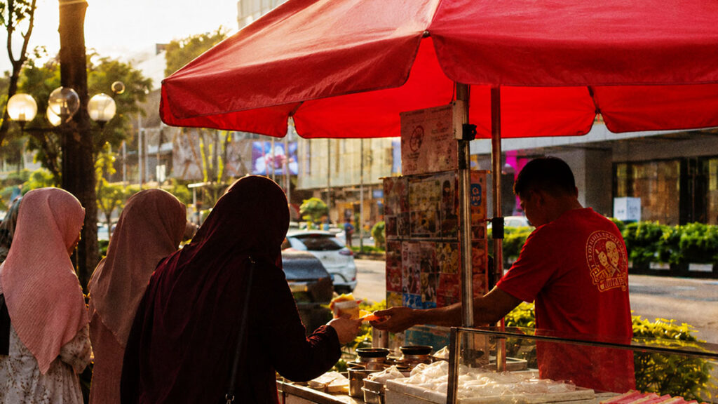 Penjual es krim roti legendaris melayani pembeli di kawasan Orchard Road Singapura pada sore hari