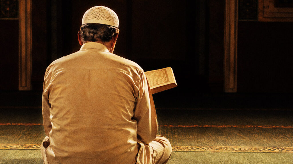 Menyambut datangnya bulan Muharram, seorang pria membaca Al-Qur'an di dalam masjid.