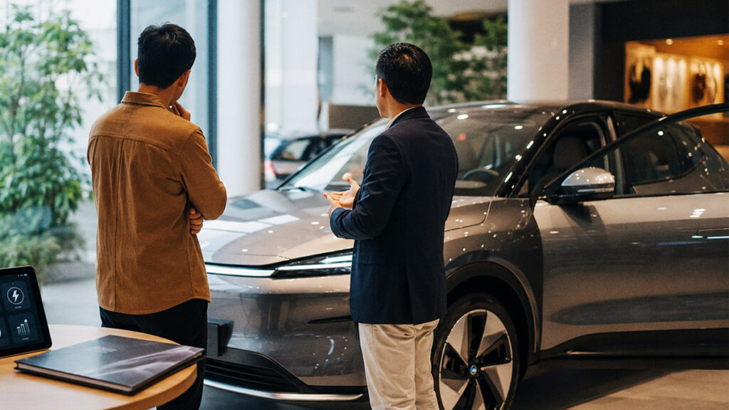Calon pembeli berdiskusi dengan sales di showroom sebelum membeli mobil listrik