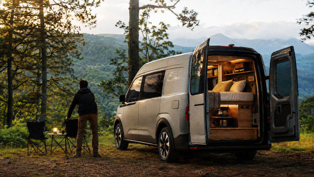 Campervan listrik dengan interior tempat tidur di area camping pegunungan