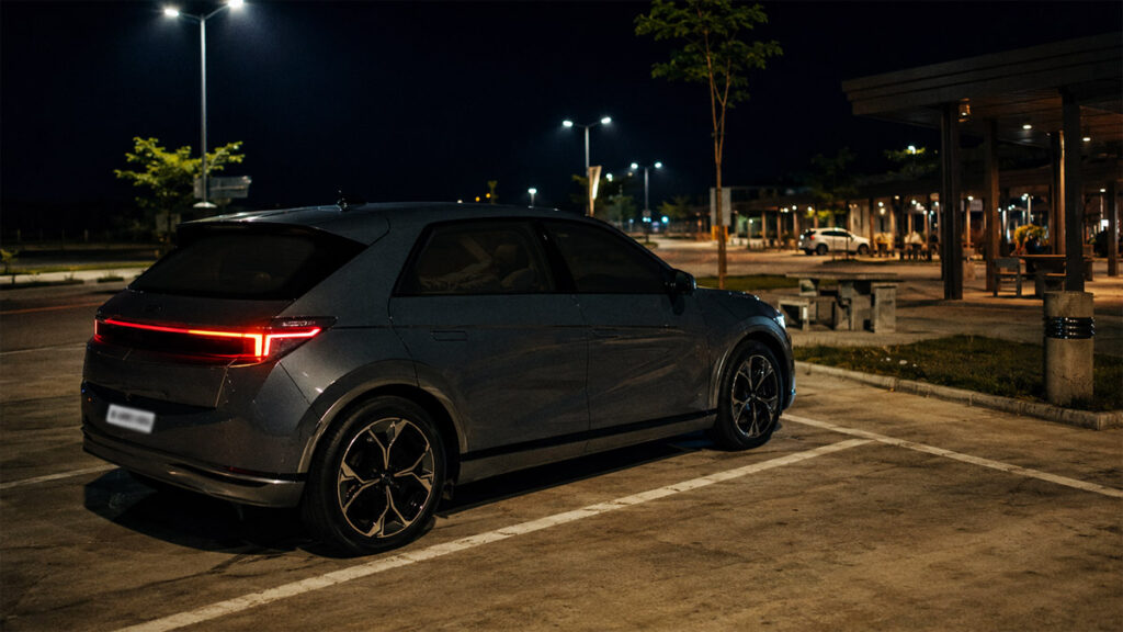 Seorang pengemudi tidur di dalam mobil listrik dengan AC menyala saat road trip malam hari